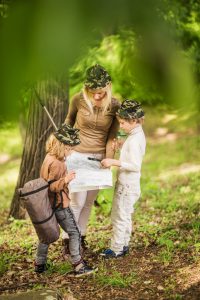 Mother exploring map with her children in nature.